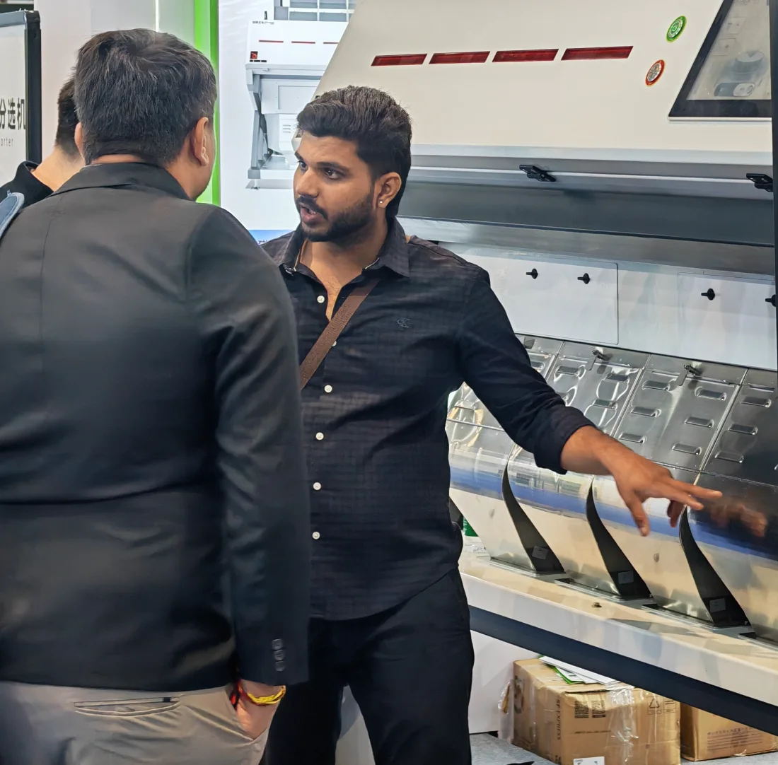 APEX engineer introduces PM series multi-dimensional plastic sorting machine to overseas buyer at APEX Booth